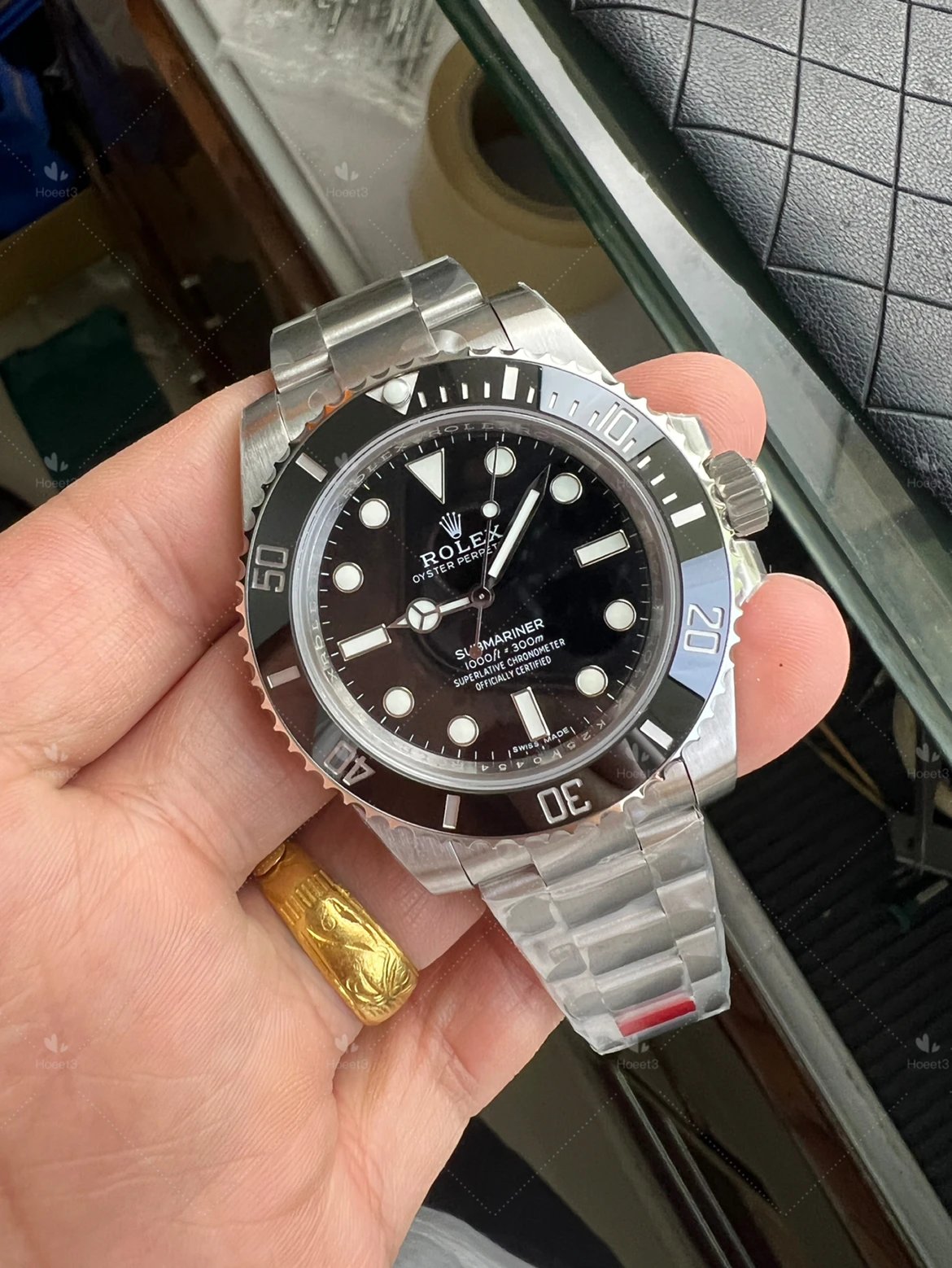 Supplier catalog photograph of a black no-date VSF Submariner held in a hand